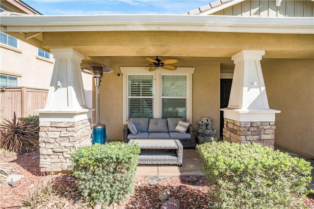 entrance to property featuring ceiling fan, fence, board and batten siding, and stucco siding