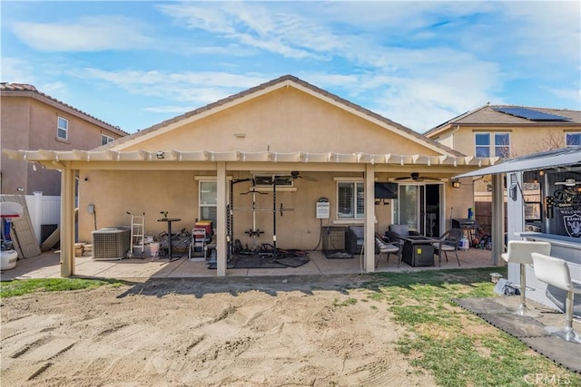 rear view of property featuring central air condition unit, a patio area, ceiling fan, and stucco siding