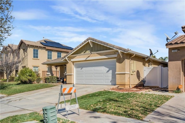 view of front of property featuring stucco siding, solar panels, an attached garage, driveway, and a front lawn