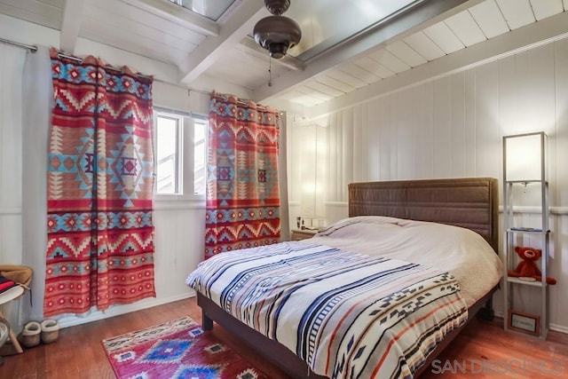 bedroom featuring beamed ceiling, wood ceiling, and hardwood / wood-style floors