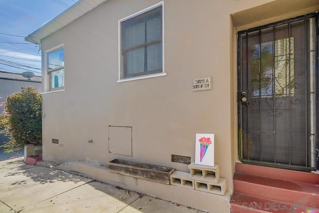 view of exterior entry with a patio area