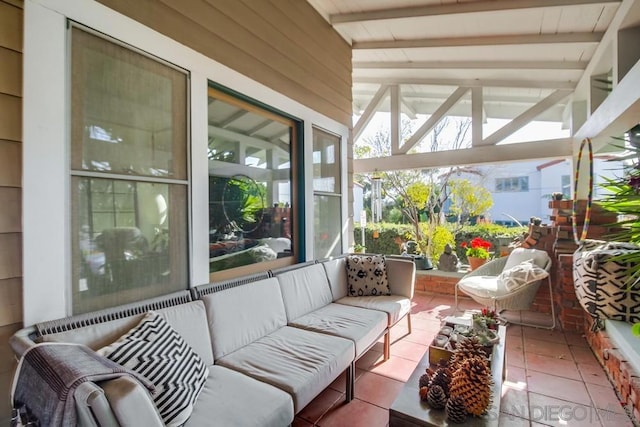 sunroom / solarium featuring vaulted ceiling with beams