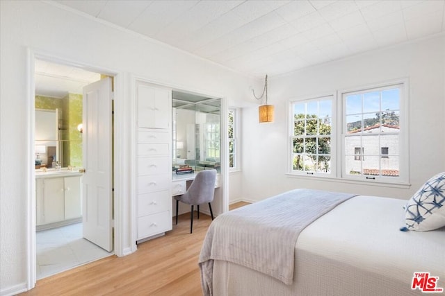 bedroom featuring wood-type flooring, ornamental molding, and built in desk