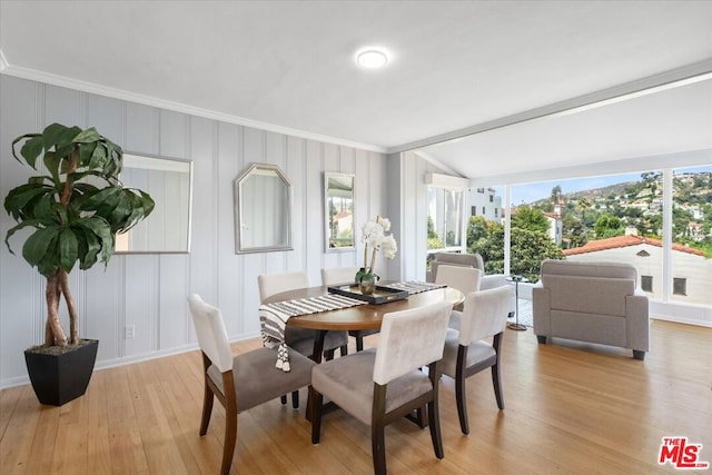 dining room with crown molding and light hardwood / wood-style flooring