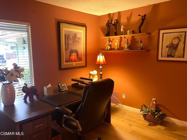 office space with light wood-type flooring and a textured ceiling