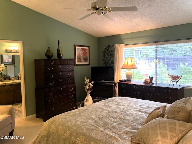 carpeted bedroom with ensuite bathroom, lofted ceiling, ceiling fan, and a textured ceiling