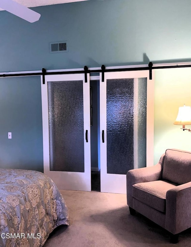 carpeted bedroom featuring a barn door