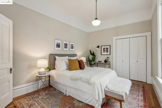 bedroom with dark hardwood / wood-style flooring and a closet