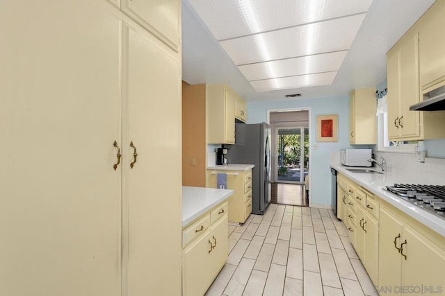 kitchen with sink, cream cabinetry, and appliances with stainless steel finishes