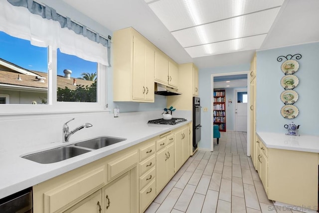 kitchen featuring sink, dishwasher, black double oven, cream cabinets, and stainless steel gas stovetop