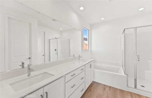 bathroom with vanity, hardwood / wood-style floors, and independent shower and bath