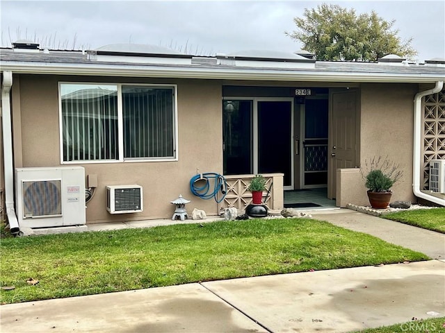 back of property featuring ac unit and a lawn