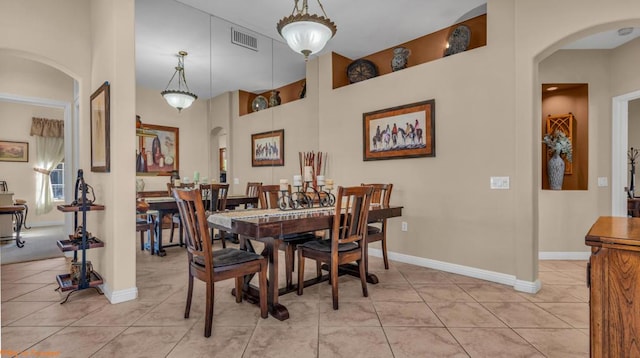 tiled dining room featuring a towering ceiling