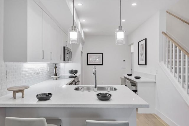 kitchen with pendant lighting, a kitchen bar, and kitchen peninsula