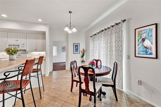 tiled dining space with an inviting chandelier