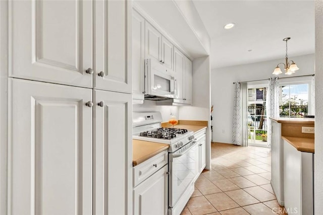 kitchen with light tile patterned floors, white cabinets, white appliances, and decorative light fixtures