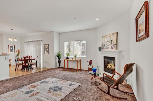 living area with an inviting chandelier and light colored carpet