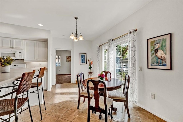 tiled dining room with a notable chandelier