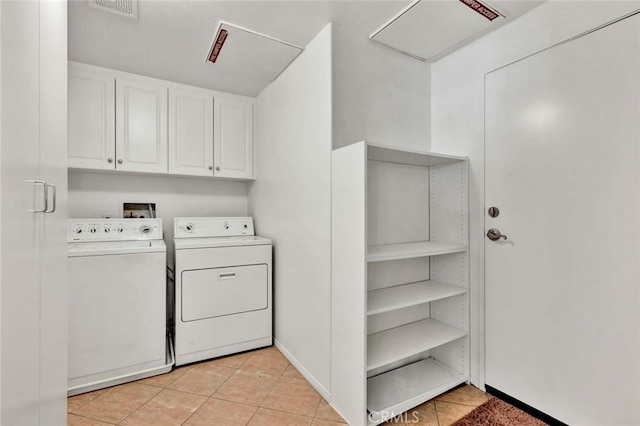 laundry area featuring separate washer and dryer, light tile patterned floors, and cabinets