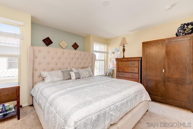 bedroom with light carpet and a closet