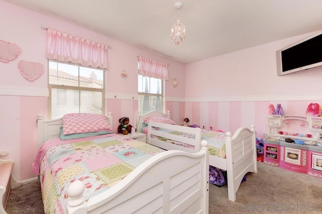 carpeted bedroom featuring an inviting chandelier