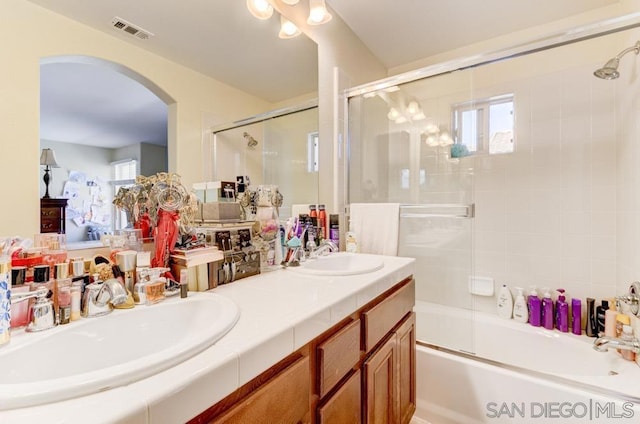 bathroom featuring vanity and combined bath / shower with glass door