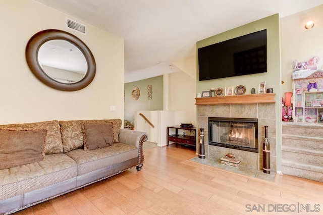 living room featuring hardwood / wood-style flooring and a tiled fireplace