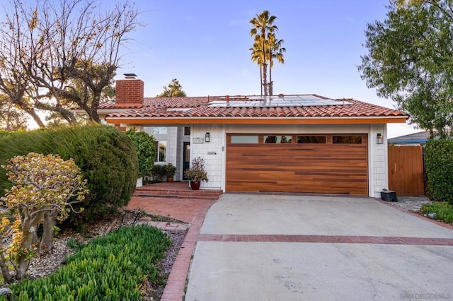 view of front of house featuring a garage and solar panels