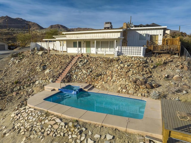 view of swimming pool featuring an in ground hot tub and a mountain view