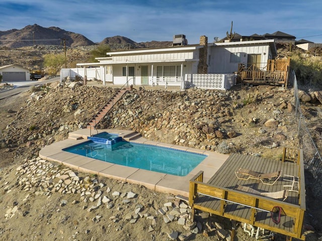 view of pool featuring a mountain view, a patio, and an in ground hot tub