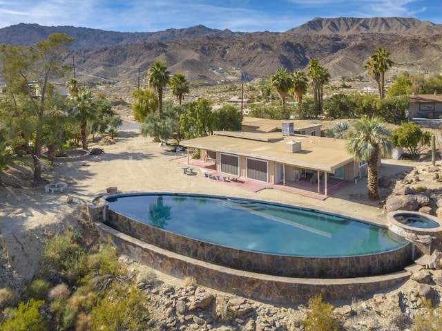 view of swimming pool featuring a mountain view and a patio