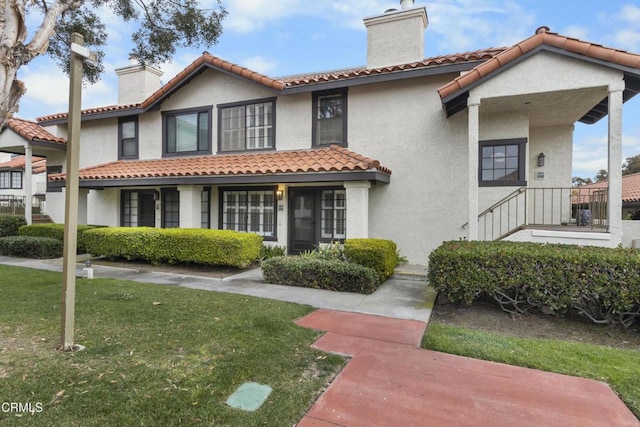 mediterranean / spanish-style house featuring a front yard