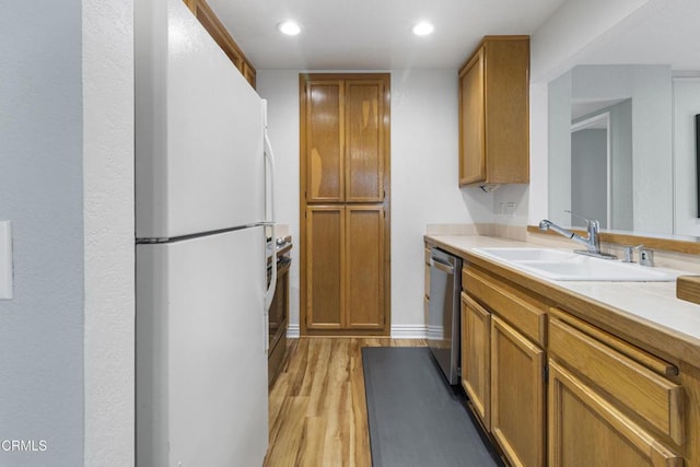 kitchen with white refrigerator, sink, stainless steel dishwasher, and light hardwood / wood-style flooring