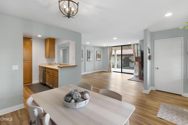 dining room featuring a chandelier, sink, and light hardwood / wood-style flooring