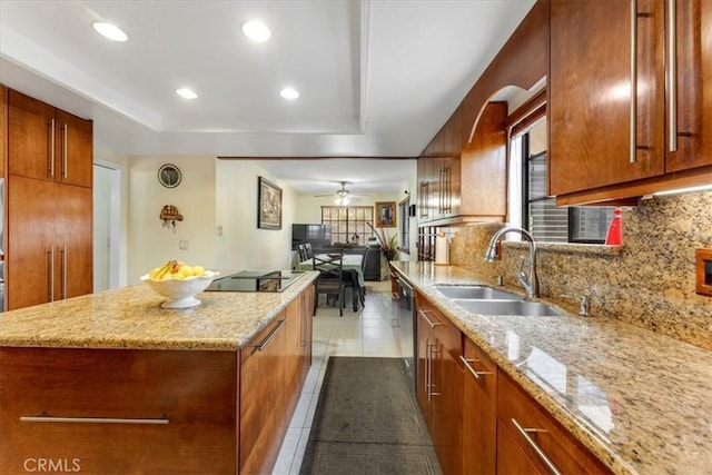 kitchen featuring light stone countertops, sink, backsplash, and black electric cooktop