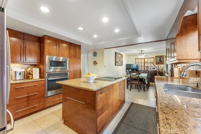 kitchen with a kitchen island, appliances with stainless steel finishes, sink, and backsplash