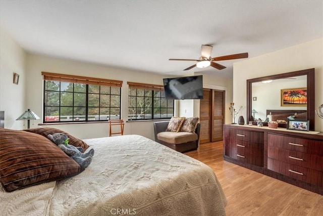 bedroom with a closet, ceiling fan, light hardwood / wood-style floors, and multiple windows