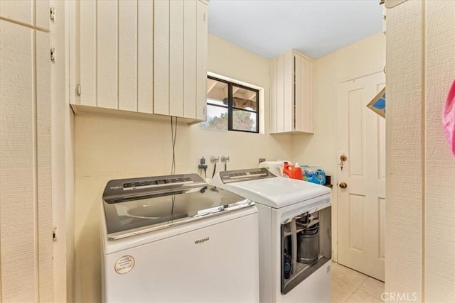 laundry room featuring cabinets, light tile patterned floors, and independent washer and dryer