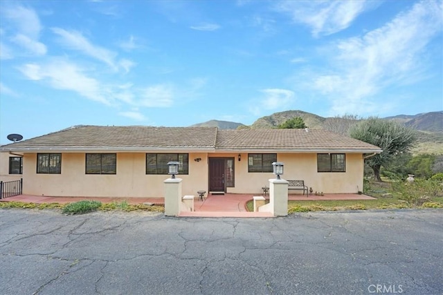 single story home with a mountain view and a patio area