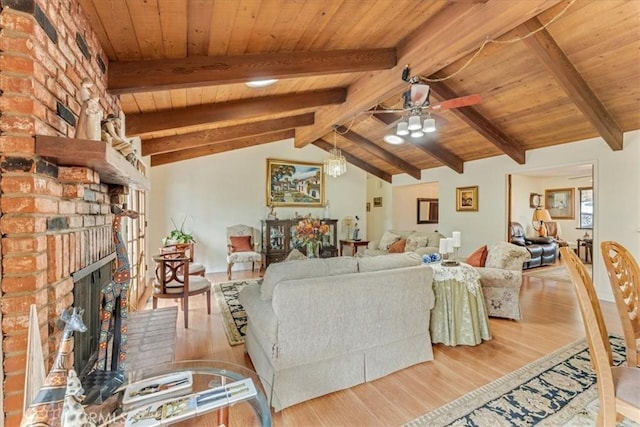 living room with a fireplace, light hardwood / wood-style floors, lofted ceiling with beams, and wooden ceiling