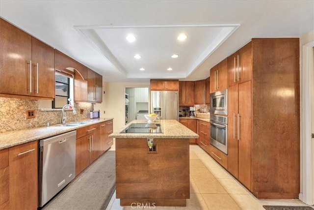 kitchen with light tile patterned flooring, sink, a center island, appliances with stainless steel finishes, and a raised ceiling