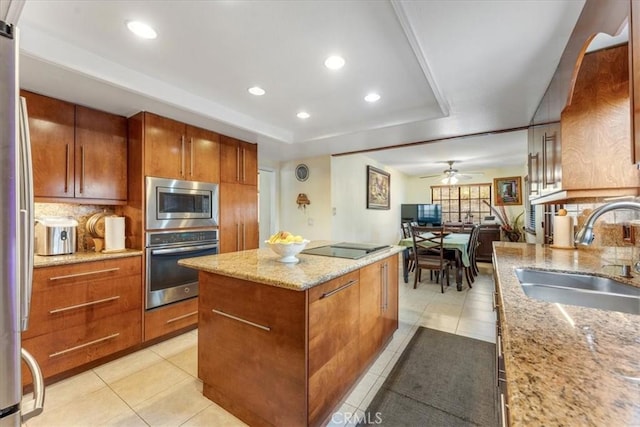 kitchen with stainless steel appliances, a center island, sink, and backsplash