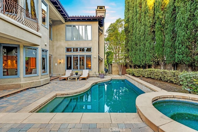 view of pool with a patio and an in ground hot tub