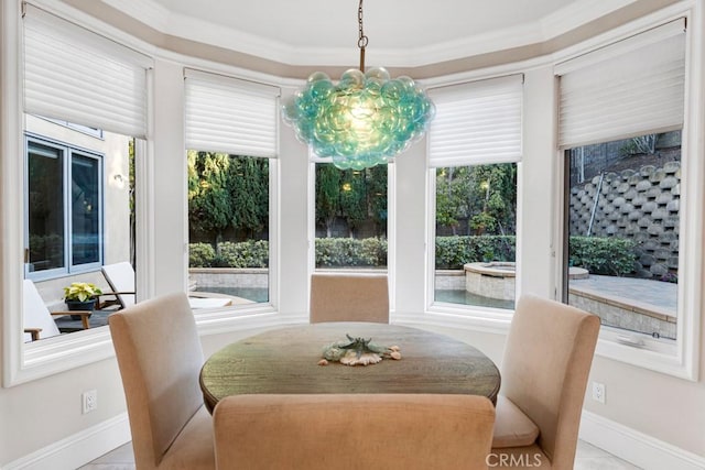 dining space featuring crown molding, a healthy amount of sunlight, and an inviting chandelier