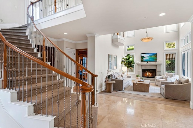 staircase with crown molding, tile patterned flooring, and a towering ceiling