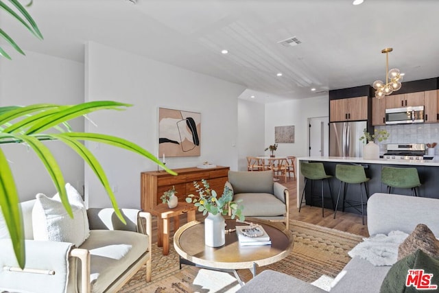 living room featuring a chandelier and light hardwood / wood-style flooring