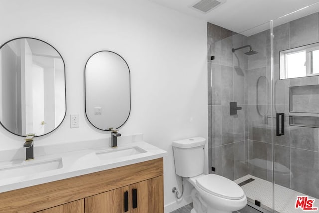 bathroom with vanity, toilet, and a shower with shower door