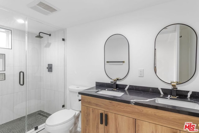 bathroom with walk in shower, vanity, and toilet