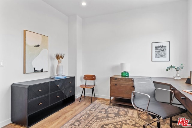 home office with light hardwood / wood-style flooring