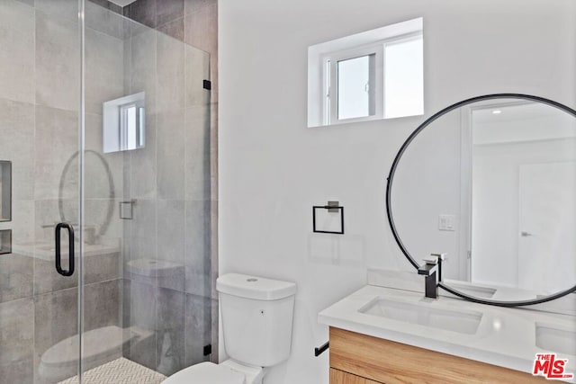 bathroom featuring vanity, an enclosed shower, and toilet